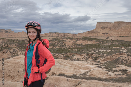 Fotografie Young woman mountain bike cyclist in Badlans of Navarre (Bardenas Reales de Navarra) dessert in the middle of Spain