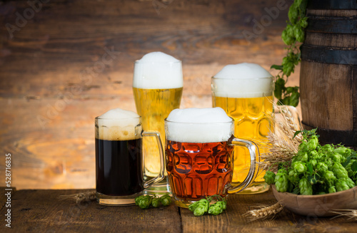 Different kinds of light and dark beer in the glasses on the wooden table 