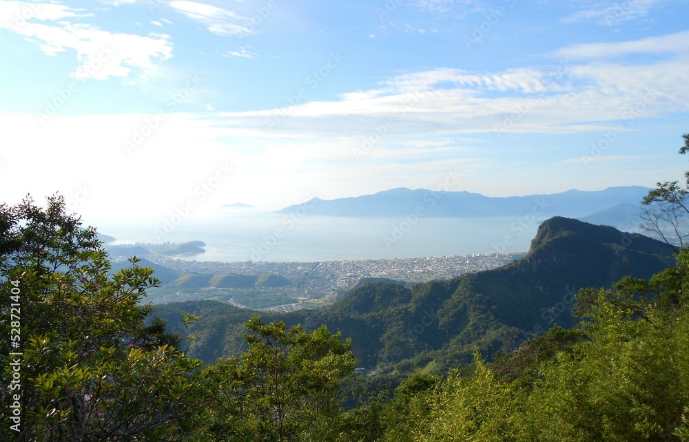 Mountains, a lot of green, the sea in the background and below the city of Caraguatatuba, São Paulo, Brazil.
