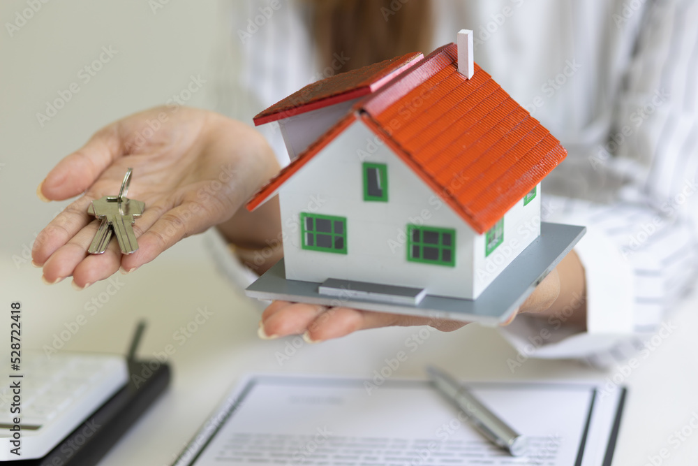 Real estate concept for rent, mortgages, home insurance. and signing a house purchase agreement. Real estate agents are offering house keys. Real estate concept for rent, mortgages, home insurance. and signing a house purchase agreement. Real estate agents are offering house keys.
