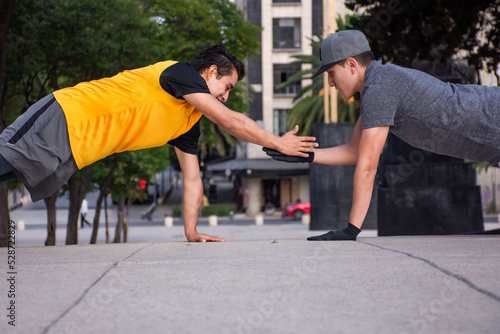 Two young men doing exercise together in a park
