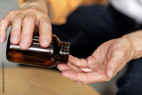 Old man hands holding medicine, closeup shot