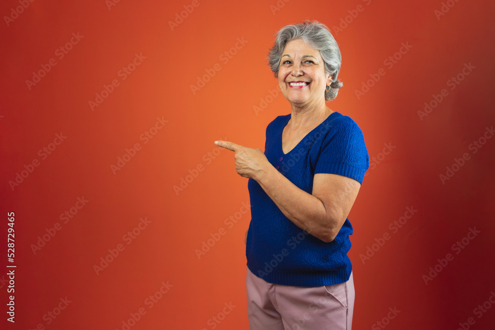 Portrait of Smiling Woman With Gray Hair and Blue T-Shirt, Isolated Over Orange Background