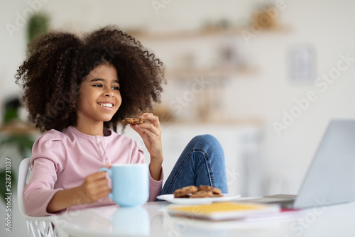 Cheerful black girl having break while studying at home
