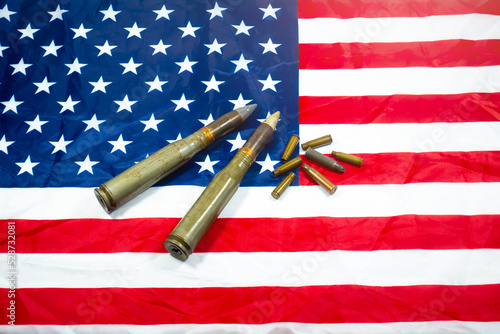 American flag with bullets, shells, cartridges and projectiles on it. Lend-Lease concept. Army concept. Sales of weapons and ammunition. Military industry, war, global arms trade.