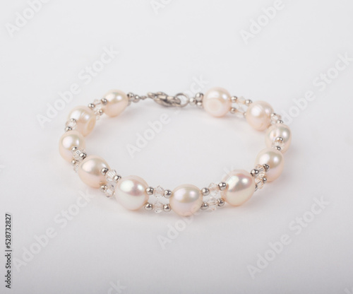 Genuine pink pearl bracelet decorated with bead isolated on white background