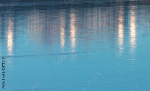 Blue ice rink surface with reflections, background texture