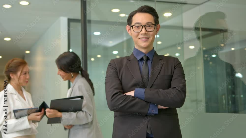 Young, handsome and friendly face man smile with happy and self-confident positive expression with crossed arms on office background. Young, handsome and friendly face man smile with happy and self-confident positive expression with crossed arms on office background.