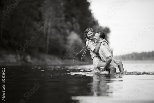 Guy and girl kiss standing in the water.