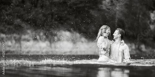 Guy and girl kiss standing in the water.