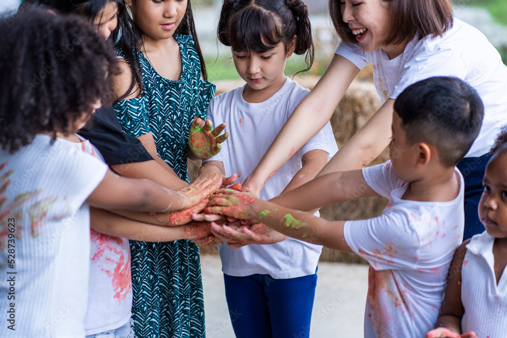group of Asian and African children of various nationalities and teacher join hands with volunteers to collect garbage in the school garden. group of Asian and African children of various nationalities and teacher join hands with volunteers to collect garbage in the school garden.
