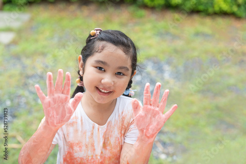 Portrait of cute Asian little girl showing hands painted in colors.education concept
