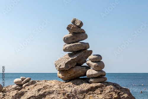 Close-up of stacked pebbles on the beach against a clear sky