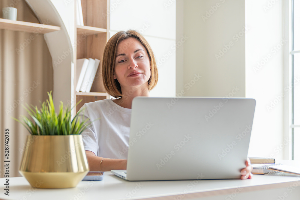 Young female student sitting at the desk at home and preparing for a new academic year. Education and online training concept Young female student sitting at the desk at home and preparing for a new academic year. Education and online training concept