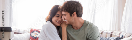 Smiling woman with closed eyes hugging boyfriend in camper van, banner