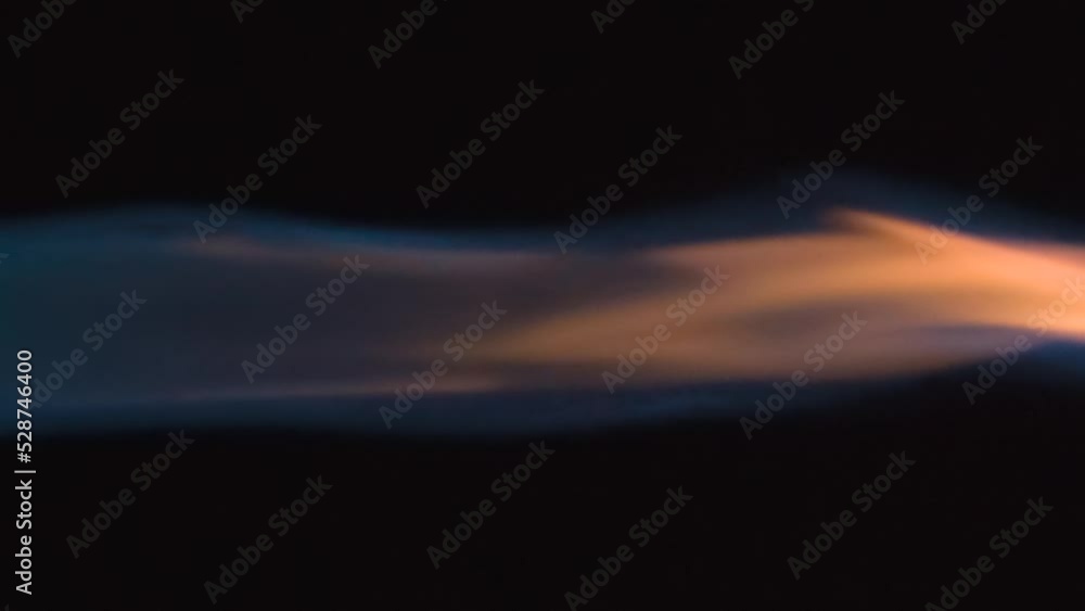 Fiery Jet of Burning Gas. Burning blue gas jet sways with a bright orange tongue of flame against a black background. Slow Motion 120 fps Fiery Jet of Burning Gas. Burning blue gas jet sways with a bright orange tongue of flame against a black background. Slow Motion 120 fps