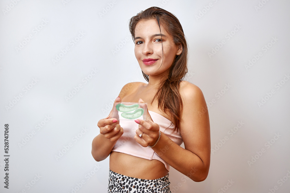 The girl uses collagen hydrogel patches under her eyes. Beauty concept, cosmetics for skin care around the eyes, lifting. Beauty salon. Wrinkle removal. The girl uses collagen hydrogel patches under her eyes. Beauty concept, cosmetics for skin care around the eyes, lifting. Beauty salon. Wrinkle removal.