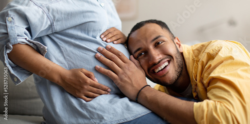 Black Husband Listening To Pregnant Wife's Belly Indoor, Panorama, Cropped