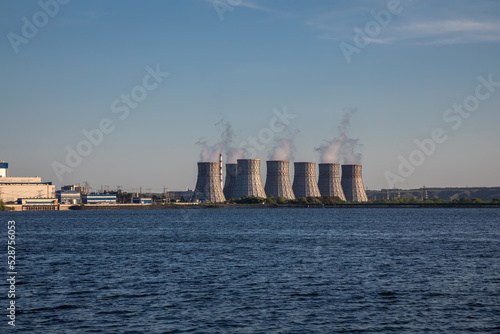 A beautiful nuclear power plant on the banks of the river. Big pipes. Power units of the station's atmospheric power plant. Sunny evening. Beautiful water.