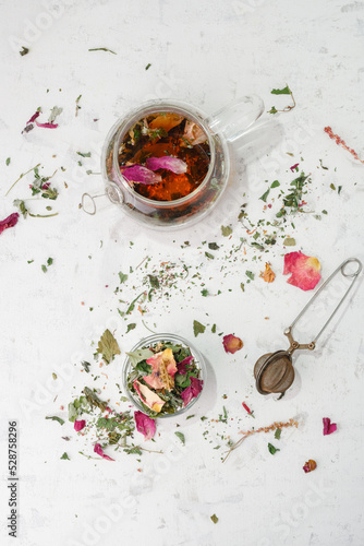 Herbal tea. Detox. Dry tea and brewed tea in a glass teapot on a white wooden background