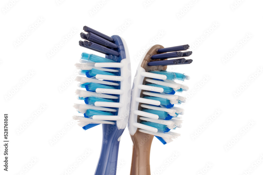 Two plastic toothbrushes, close-up, isolated on a white background. Two plastic toothbrushes, close-up, isolated on a white background.