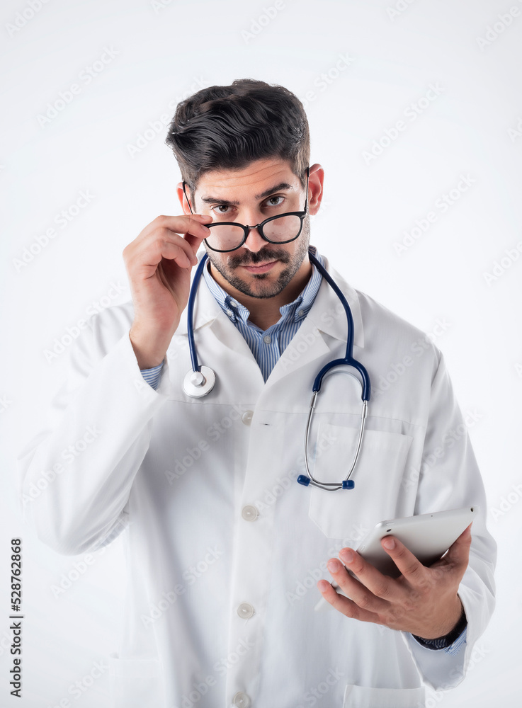 Male doctor using digital tablet while standing at isolated background Male doctor using digital tablet while standing at isolated background
