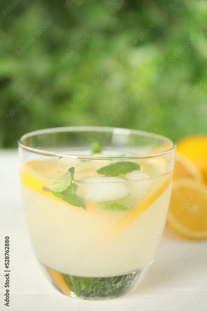 Cool freshly made lemonade in glass on white table Cool freshly made lemonade in glass on white table