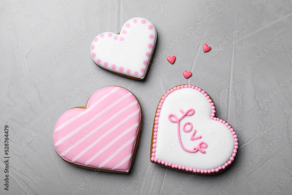Obraz premium Decorated heart shaped cookies on grey table, flat lay. Valentine's day treat