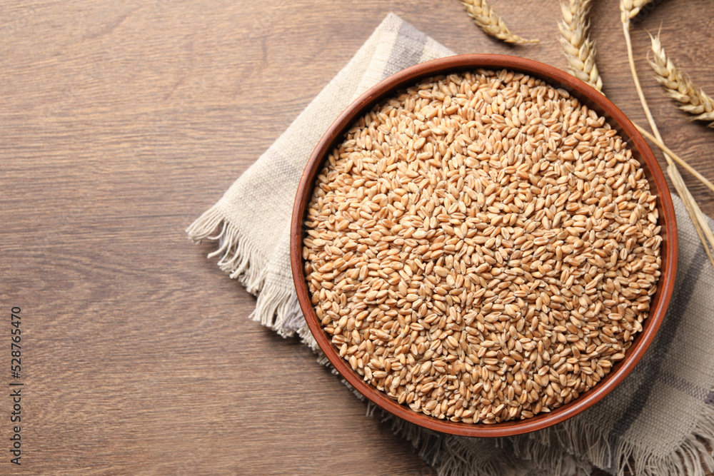 Wheat grains and spikes on wooden table, flat lay. Space for text Wheat grains and spikes on wooden table, flat lay. Space for text