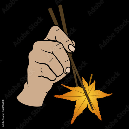 Human hand holding yellow autumn leaf of storax tree with chopsticks. Creative vegetarian food design. On black background. photo
