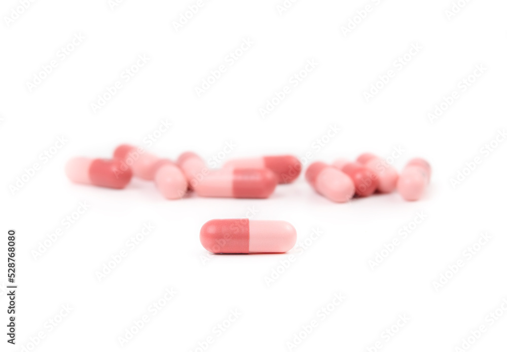 Isolated gel capsules. Multiple pink softgel capsules randomly placed. Used to administer drugs, medicine, supplements or oil for people or pets. Selective focus on one capsule in front. Isolated gel capsules. Multiple pink softgel capsules randomly placed. Used to administer drugs, medicine, supplements or oil for people or pets. Selective focus on one capsule in front.