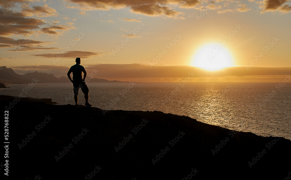 Silhouette of a man in the evening light at sunset on the west coast of Fuerteventura