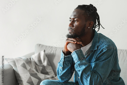 Serious African American Man Thinking Sitting At Home, Side View