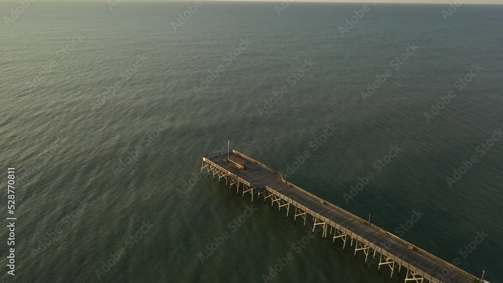 Fishing pier in early morning sun at coastal vacation destination