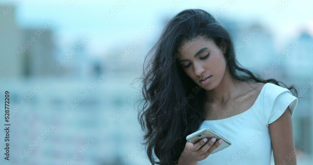 Multiracial young black african girl holding smartphone device Multiracial young black african girl holding smartphone device