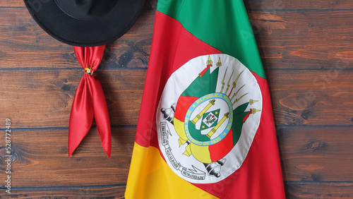 Flag of the state of Rio Grande do Sul -Brazil (on fabric), hat and gaucho scarf, on a brown background. photo