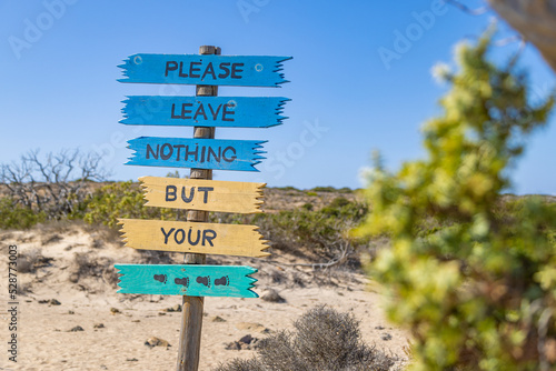 Colorful sign with message "Please leave nothing but your footprints" on Chrysi island, Crete, Greece