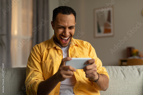 Leinwand Poster Overjoyed young black man with smartphone feeling excited over winning lottery o