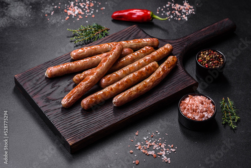 Grilled sausage with the addition of herbs and vegetables on the wooden cutting board