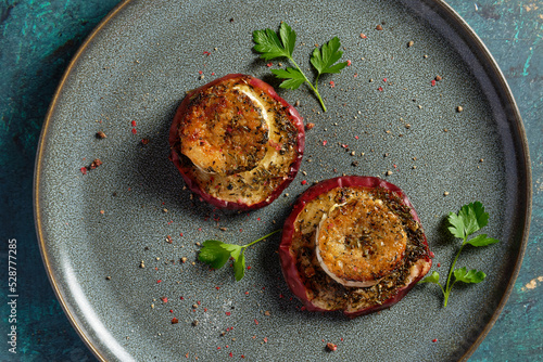 Baked goat cheese on apple slices with thyme, served on a plate. photo