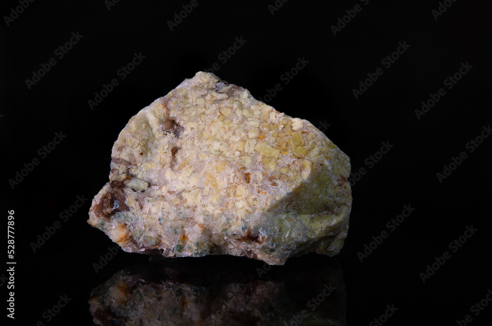 A fragment of the raw light yellow mineral opal with brown patches A fragment of the raw light yellow mineral opal with brown patches