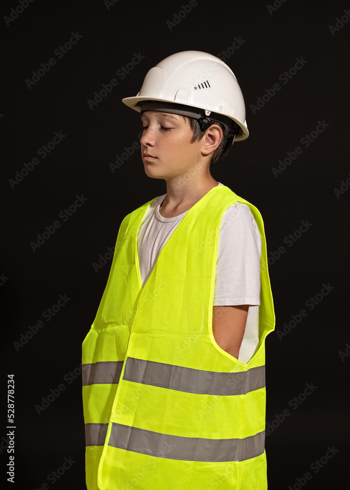 a teenager in a helmet vest stands with his eyes closed. a teenager in a helmet vest stands with his eyes closed.