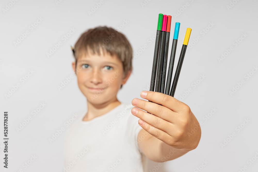 Colored pencils in the hands of a teenager. The concept of artistry. Colored pencils in the hands of a teenager. The concept of artistry.