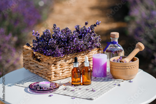 Dropper bottle with lavender cosmetic oil or hydrolate against lavender flowers field as background with copy space. Herbal cosmetics and modern apothecary concept photo