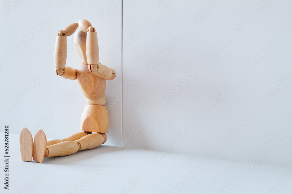 Concept of despair and regret with a wooden doll with his hands on his head Concept of despair and regret with a wooden doll with his hands on his head