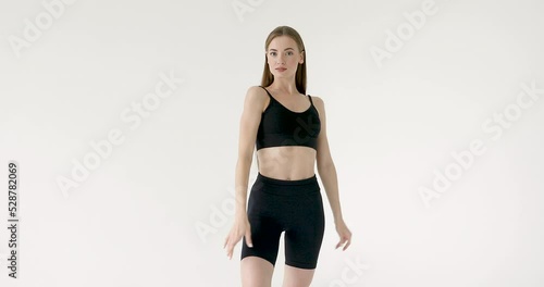 Slim sporty fitness young woman gymnast in sportswear posing on a white background. Sport motivation, physical education