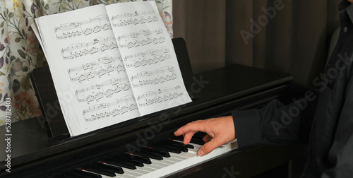 Photography black piano and sheet music, man plays