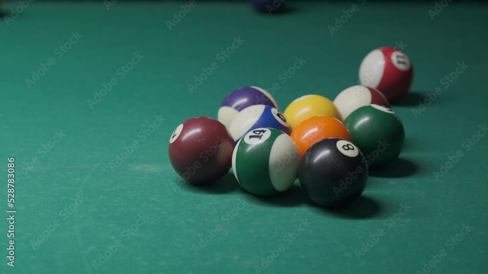 The cue ball breaks stacked balls. Game in the American pool.