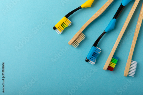 Toothbrushes. Oral care. Dental care. Composition with different toothbrushes on a blue background. Teeth love concept.Copy space. Place for text.Fletley