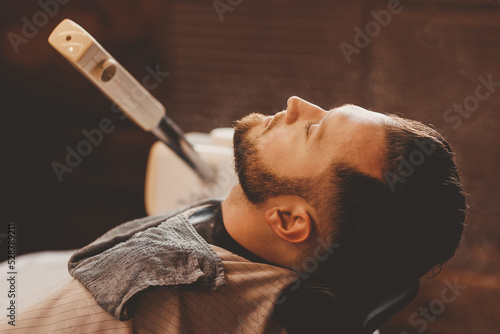 Vaporizer for face man in barbershop. Machine steam beard softening in preparation for shaving razor, vintage color